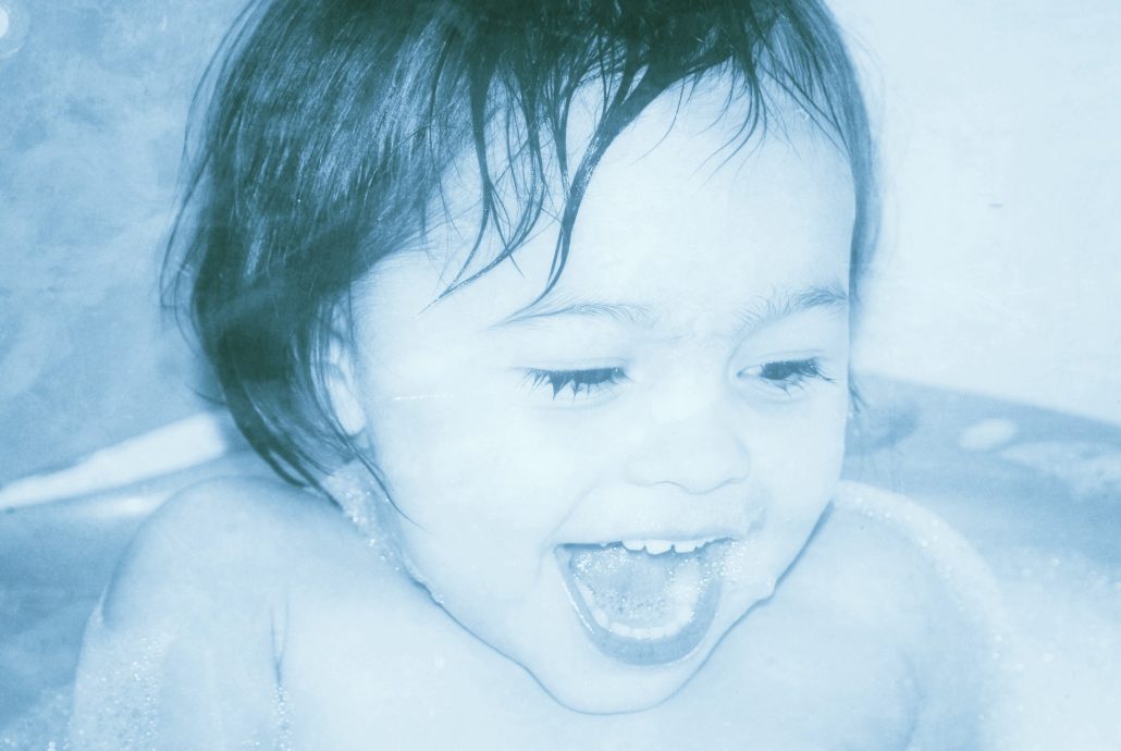 meleg vízben fürdőzik egy nevető gyerek