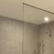 ventilátor a falon egy modern zuhanyzós fürdőszobában